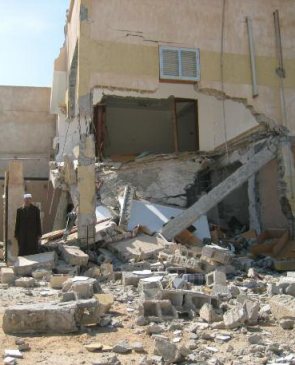 72-year-old Khamis in front of his shelled home in Misrata, Libya